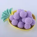 Macro shot of 20mm purple crocheted cotton yarn beads on a yellow pineapple-shaped tray - Purple