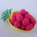 Close-up of 20mm magenta crochet cotton beads arranged in a yellow pineapple ceramic tray - Rose Red