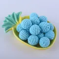 Detailed close-up of 16mm light blue hand-crocheted cotton beads in a pineapple dish - Sky Blue