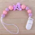 Silikon-Schnullerkette mit lila Koala-Perle und rosa Perlen auf Holzmaserungshintergrund - Koala - Lila