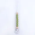 Detail of green silicone and wood beads on a baby pacifier clip with a metal fastener - Avocado Green