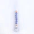 Detail of baby pacifier clip with purple silicone beads and natural wooden accents - Violet