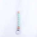 Close-up of mint green silicone beads and natural wood beads on a baby pacifier clip - Light Green