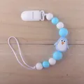 Silicone pacifier clip with blue penguin and beads on a natural wooden background - Penguin Blue