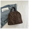 Close-up of leopard print tote lunch bag with brown canvas straps and corduroy texture - Coffee Leopard
