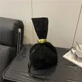 Κομψή μαύρη σουέτ τσάντα πουγκί με μια εμφανή χρυσή μεταλλική αγκράφα ως έμφαση - Μαύρο