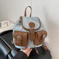 Mini light blue denim backpack with brown leather trim and two front buckle pockets - Blue
