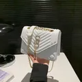 Elegant white quilted crossbody bag with gold chain strap and artistic tassel clasp - White