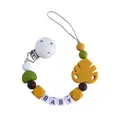 Baby pacifier clip with yellow leaf and silicone beads featuring the word BABY - Turmeric