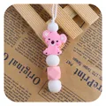 Pink silicone koala teething pendant with geometric beads on a white cord - Pink