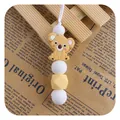 Silicone teething necklace featuring a yellow koala pendant and geometric white beads - Turmeric