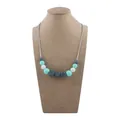 Silicone teething necklace for infants with grey, white, and mint green beads on bust - Mint Green