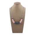 Silicone teething necklace for babies with pink white and grey beads on a neck form - Pink