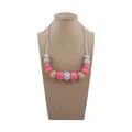 Baby teething necklace with pink, marble grey, and natural wood beads on a display stand - Deep Pink