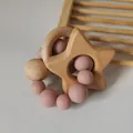 Macro shot of natural beech wood star and silicone beads teething ring for infants - Dusty Rose
