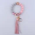 Detail of pink silicone beads, wooden hexagon bead, and faux leather tassel keychain - Pink