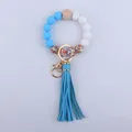 Detail of blue and white silicone bead wristlet with wood bead and floral pattern accents - Blue