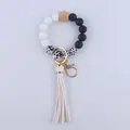Close-up of leopard print silicone beads and white leather tassel on a wristlet keychain - White