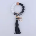 Close-up of beaded keychain with black leather tassel, silicone skulls, and golden hardware - Black and White