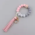 Detail of pink silicone beaded wristlet keychain with wooden bead and leather tassel - Pink