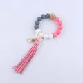 Detailansicht Silikon-Perlenarmband mit Holzperle und rosa Lederquaste Anhänger - Dunkelrosa