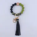 Detail of beaded wristlet keychain with leopard print, tassel, and matte olive beads - Black