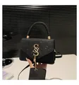 Dettaglio borsa nera con paillettes, logo SS in metallo dorato e nappine alla moda - Nero