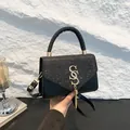 Sac bandoulière noir chic avec rabat pailleté argenté et boucle dorée SS à pompons - Noir
