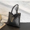 Classic black leather tote bag featuring a geometric block texture and long shoulder straps - Black