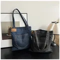 Sacs cabas en denim bleu foncé et noir avec détails de poches vintage sur bois - Bleu foncé