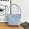 Sac à main bleu clair élégant avec texture froissée et logo triangulaire chic - Bleu