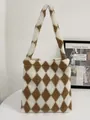 Detailopname van de pluche argyle draagtas met zachte lamswol textuur in bruin wit - Bruin