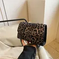 Detalle del bolso de leopardo con remaches metálicos y correa de cadena chic - café