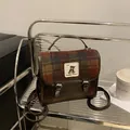 Dettaglio ravvicinato di borsa in lana a quadri con bordi in pelle retro e patch orso - senza ciondolo / Marrone