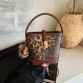 Detail der Bucket-Bag mit Leopardenmuster, Metalldrehverschluss und Plüschanhänger - Braun