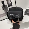 Detail view of black canvas crossbody bag with sausage dog print and cloud charm accessory - Black