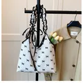 Primer plano de un bolso de lona blanca con lunares negros y elegantes lazos decorativos - Blanco