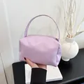 Close-up of light purple leather handbag featuring metal zipper and top handle detail - Purple