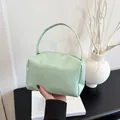 Handheld mint green PU leather handbag featuring a minimalist pillow-shaped design and long straps - Green
