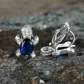 Creative turtle ear clip with deep blue gemstone and white zircon on grey stone background - Sapphire Blue