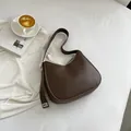 Vintage bruine leren hobo schoudertas met zilveren gesp in een minimalistisch design - Bruin