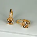 Dettaglio macro di orecchini in zircone ambra tondo con finitura dorata - Oro Zirconia Champagne