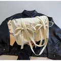 Borsa tote in nylon bianco crema con fiocco su sfondo giacca di pelle nera - Beige