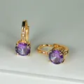 Dettaglio di orecchini a cerchio dorati con grande zircone viola rotondo e piccoli cristalli - Placcato Oro Zircone Viola