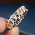 Macro view of gold eternity ring featuring rectangular cubic zirconia in claw setting - US 7 / Gold White Zirconia