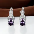 Makroaufnahme ovaler violetter Kristallohrringe mit silbernem Verschluss und Diamanten - Platiniert Violetter Zirkonia