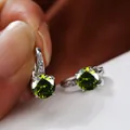 Dettaglio macro di orecchini d'argento con pietre verde oliva e cristalli in micro-pavé - Platino Verde Oliva