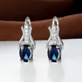 Dettaglio di orecchini pendenti in argento con pietra blu ovale e piccoli zirconi chiari - Placcato Platino Blu Reale