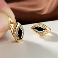 Détails macro de boucles d'oreilles plaquées or avec gemme noire et zircons blancs - Noir