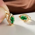 Détail de boucles d'oreilles marquise avec pierre verte et filigrane doré ciselé - Vert